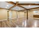 Spacious basement with wood-look flooring, exposed wooden beams and supports, and tan walls at 5432 E Bails Dr, Denver, CO 80222