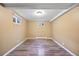 Finished basement area featuring wood-look flooring, neutral walls and window wells at 5432 E Bails Dr, Denver, CO 80222