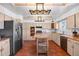 Bright and spacious kitchen with a rustic wood island, stainless steel appliances, and stylish light fixtures at 5432 E Bails Dr, Denver, CO 80222
