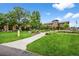Beautiful building exterior featuring lush landscaping, sidewalk, and mature trees under a blue sky at 13890 E Marina Dr # 304, Aurora, CO 80014
