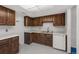 A compact kitchen featuring wooden cabinets, laminate countertops, and essential appliances at 13890 E Marina Dr # 304, Aurora, CO 80014