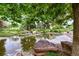 Scenic pond surrounded by lush greenery, rocks, and mature trees, enhancing the community landscape at 13890 E Marina Dr # 304, Aurora, CO 80014