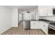 Bright kitchen with stainless appliances, open layout, and hardwood floors at 657 Locust Ave, Lochbuie, CO 80603