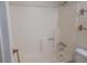 Bright bathroom with bathtub and shower, wooden towel bars and white fixtures at 1845 N Kendall St # 316D, Lakewood, CO 80214