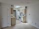 Compact kitchen features white appliances, tile floors and a sun-filled sky light at 1845 N Kendall St # 316D, Lakewood, CO 80214
