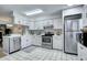 Bright kitchen featuring white cabinetry, stainless steel appliances, and tile flooring at 19804 Summerset Ln, Parker, CO 80138