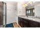 A full bathroom includes double sinks, granite countertops, and a glass-enclosed shower at 10125 Zeno St, Commerce City, CO 80022