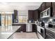 Kitchen with dark cabinets, stainless steel appliances and a view to the exterior at 10125 Zeno St, Commerce City, CO 80022