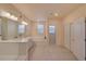 Large bathroom featuring a tub, dual sinks, and plenty of counter space at 148 Ambrose St, Erie, CO 80516