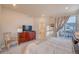 Bright main bedroom featuring a balcony, television on top of a wooden dresser, and ensuite bathroom with a soaking tub at 148 Ambrose St, Erie, CO 80516