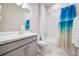 Bathroom with a white sink and cabinet, white tile, and a shower with a blue curtain at 195 Silver Rock Trl, Castle Rock, CO 80104