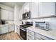 Detailed shot of modern kitchen featuring stainless steel appliances, white backsplash, and gray cabinets at 195 Silver Rock Trl, Castle Rock, CO 80104