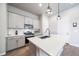 Close-up of kitchen island with stainless steel sink, gray cabinetry, and modern pendant lighting at 195 Silver Rock Trl, Castle Rock, CO 80104