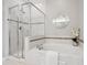 Bright bathroom featuring tiled shower, soaking tub and silver framed round mirror at 10134 Bluffmont Ln, Lone Tree, CO 80124