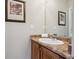 Bathroom featuring wood cabinets, speckled countertop, and framed mirror at 10134 Bluffmont Ln, Lone Tree, CO 80124