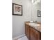 Bathroom featuring wood cabinets, speckled countertop, and framed mirror at 10134 Bluffmont Ln, Lone Tree, CO 80124