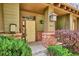 Close-up of a front porch with a yellow door, brick accents and manicured bushes at 10134 Bluffmont Ln, Lone Tree, CO 80124