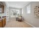 Bright sitting area featuring a charming wet bar, complemented by built-in shelving and expansive windows at 10134 Bluffmont Ln, Lone Tree, CO 80124