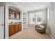 Inviting sitting area showcasing a charming wet bar, complemented by built-in shelving and a relaxing armchair at 10134 Bluffmont Ln, Lone Tree, CO 80124