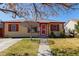 Charming single-story home with a well-manicured lawn and a red front door at 2317 Elmira St, Aurora, CO 80010