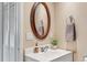 Bathroom featuring an oval mirror, vessel sink, and neutral color scheme at 30313 Arena Dr, Evergreen, CO 80439