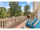 A view of the deck featuring comfortable Adirondack chairs overlooking a scenic landscape of trees at 30313 Arena Dr, Evergreen, CO 80439