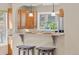 Kitchen breakfast bar features granite countertop, wooden cabinets, and a window with lovely natural light at 30313 Arena Dr, Evergreen, CO 80439