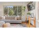 Bright living room featuring hardwood floors, and large window with green foliage view at 30313 Arena Dr, Evergreen, CO 80439