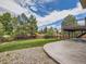 Landscaped backyard with patio, manicured lawn, and mature trees at 9412 La Quinta Way, Lone Tree, CO 80124
