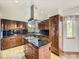 Modern kitchen with dark wood cabinets, granite countertops, stainless steel appliances, and an island at 9412 La Quinta Way, Lone Tree, CO 80124