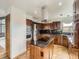 Eat-in kitchen featuring wood cabinets, black countertops, stainless steel appliances, and a kitchen island at 9412 La Quinta Way, Lone Tree, CO 80124