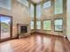 Spacious living room featuring a brick fireplace, wood floors, and large windows offering ample natural light at 9412 La Quinta Way, Lone Tree, CO 80124