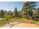 Wide shot of a back yard with trees, taken from a wooden deck with railing at 1288 Gambel Oaks Dr, Elizabeth, CO 80107