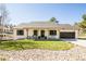 Charming single-story home featuring a well-manicured front yard and a welcoming covered porch with seating at 1288 Gambel Oaks Dr, Elizabeth, CO 80107