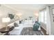 Inviting living room showcasing a white sectional, decorative pillows, and a bright window with white curtains at 1288 Gambel Oaks Dr, Elizabeth, CO 80107