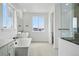 Bright bathroom with a soaking tub, shower, dual sinks, and a large window, offering a luxurious and well-lit space at 1667 Fox Trotter Pt, Castle Rock, CO 80104