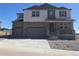 Beautiful two-story home with a stone facade and a three-car garage at 1667 Fox Trotter Pt, Castle Rock, CO 80104