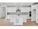 Modern kitchen featuring white cabinets, stainless steel appliances, an island with a sink, and wood floors at 1667 Fox Trotter Pt, Castle Rock, CO 80104