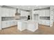 Modern kitchen featuring white cabinets, stainless steel appliances, a large island, and wood floors at 1667 Fox Trotter Pt, Castle Rock, CO 80104