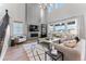 Bright, open living room featuring a modern fireplace, large windows, and stylish decor at 1667 Fox Trotter Pt, Castle Rock, CO 80104