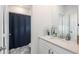 Bathroom featuring a sink with granite countertop, shaker cabinets, framed mirror and a bathtub behind a shower curtain at 688 N Bersshine Ct, Watkins, CO 80137