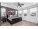 Comfortable bedroom with a violet accent wall, large windows, and neutral-toned furnishings at 688 N Bersshine Ct, Watkins, CO 80137