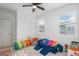 Playroom features a large window, modern ceiling fan, play tunnel and modular blue couch, creating an inviting space at 688 N Bersshine Ct, Watkins, CO 80137