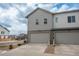 Exterior view of a townhouse, with a gray siding, two car garage and a well-manicured front yard at 688 N Bersshine Ct, Watkins, CO 80137