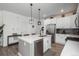 Open-concept kitchen with a large island, stainless steel appliances, and modern pendant lighting at 688 N Bersshine Ct, Watkins, CO 80137
