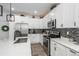 Contemporary kitchen featuring white cabinets, stainless steel appliances and a stylish tile backsplash at 688 N Bersshine Ct, Watkins, CO 80137