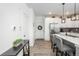 Bright entryway adjacent to a modern kitchen with white cabinets and stainless steel appliances at 688 N Bersshine Ct, Watkins, CO 80137
