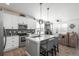 Modern kitchen with white cabinets, island with seating, and stainless steel appliances at 688 N Bersshine Ct, Watkins, CO 80137