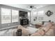 Cozy living area with a fireplace, large windows, and a comfortable sectional sofa at 688 N Bersshine Ct, Watkins, CO 80137