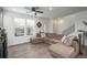 Bright and airy living room featuring large windows, modern flooring, and a sectional sofa at 688 N Bersshine Ct, Watkins, CO 80137